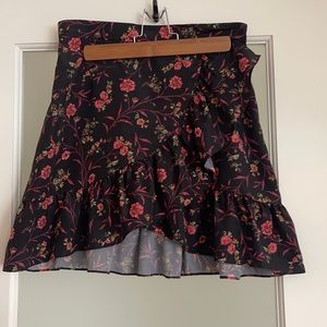 Scripted black floral mini skirt with ruffle. Size Medium.